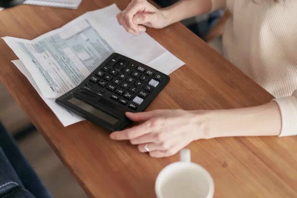Examen d'un devis de travaux avec calculatrice et documents posés sur une table